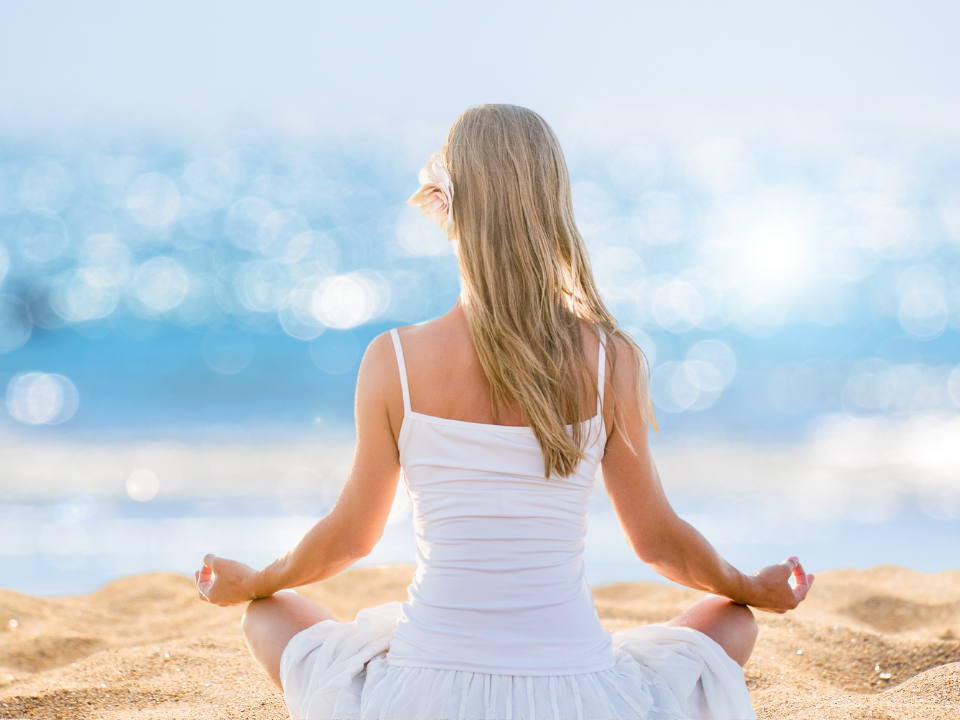 a girl meditating in the beach