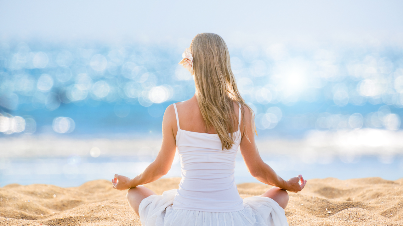 a girl meditating in the beach